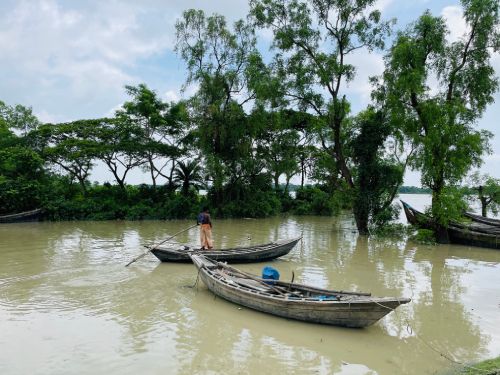Boats floating on river under cloudy sky Fisherman rowing wooden boat on calm river